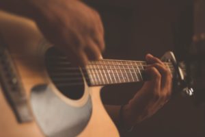Closeup of a man playing an acoustic guitar